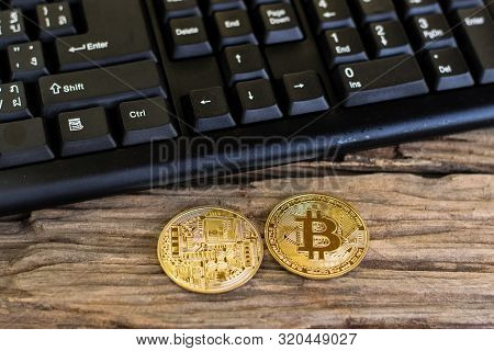 Bitcoin With Black Keyboard On Old Wood