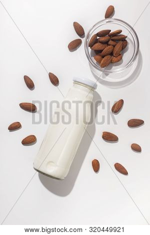 Healthy And Vegetarian Mandeln Milk In Glass Bottle On White Background With Nuts, Vertical Panorama