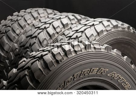 Krasnoyarsk, Russia 20 August 2019: Four Off-road Tires On Black Background. Close Up.