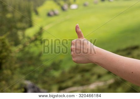 Fimale Traveler Showing Thumb Up Against The Backdrop Of Nature. Tourism Concept. Copyspace