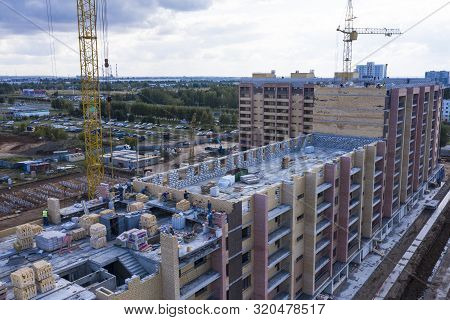 Construction Of A Multi-storey Building. Workers Lay Out A Wall Of Brick. The View From The Top.