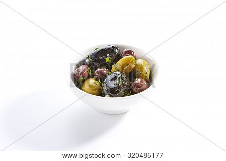 Delicious olive assorti marinated in oil closeup. Mediterranean cuisine restaurant dish, menu item. Tasty greek snack, appetizer isolated on white background. Organic food, natural vegetarian meal