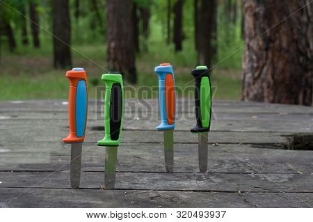 Knives Stuck On The Table. Many Colored Knives.