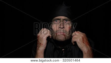 Old Executioner Halloween Man Portrait. Elderly Man With Dripping Blood On His Face. Executioner, He