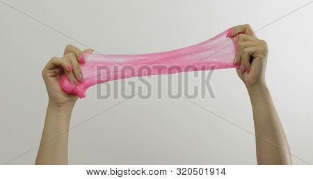 Woman Hands Playing With Oddly Satisfying Pink Slime On White Background. Sticky Gooey Substance. Re