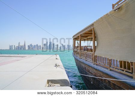 Al Dafna Architecturally Modern Skyline Across Dhow Harbour In Doha  Qatar, With Dhow Moored Alongsi