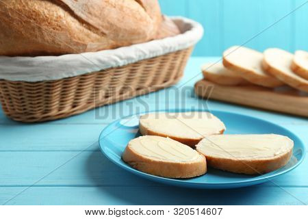 Slices Of Tasty Fresh Bread With Butter On Light Blue Wooden Table