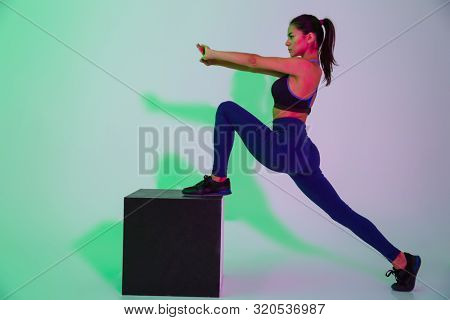 Image of pretty young sports woman posing isolated with led flash lights make stretching exercises.