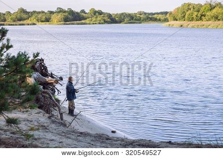 City Carnikava, Latvian Republic. Fisherman Catching Fish In The River, Nature, Silence And Water Wa