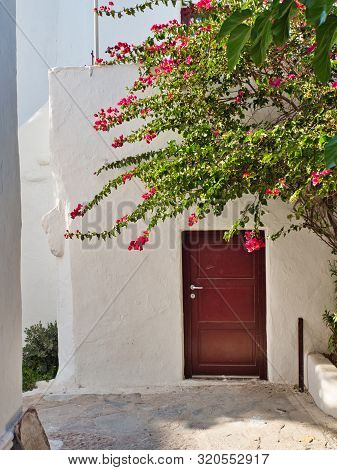 Ano Mera, Mykonos, Greece - July 23 2019 White Wall Of Old Monastery Of Panagia Tourliani With Doorw