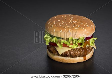 Hamburger With  Meat, Tomatoes, Salad, Onions On A Black. Copy Space