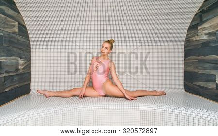 Woman doing gymnastic exercises in a steam room