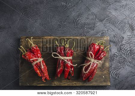 Spicy Chili On A Dark Background On A Wooden Board, Flatlay. Used As An Ingredient For Harissa, Ajik