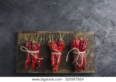 Spicy Chili On A Dark Background On A Wooden Board, Flatlay. Used As An Ingredient For Harissa, Ajik