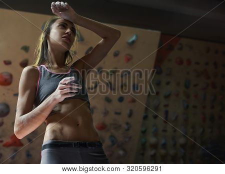 Athletic Woman With Muscular Naked Torso Is Training In Climbing Gym Indoor. Girl Is Tired And Resti