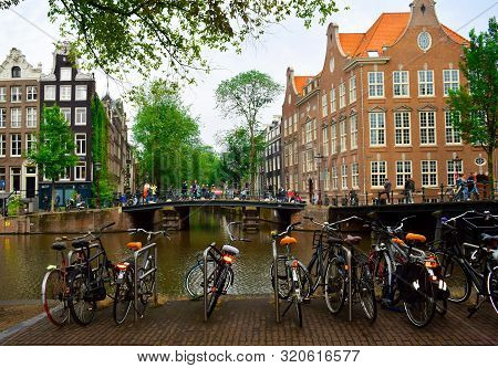 Amsterdam/ Netherlands- July 11, 2019: Amsterdam Central Street With Bicycles Parking Next To The Am