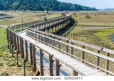 A View Of The Mud Flats And Boardwalk At The Nisqually Wetlands Near Olympia, Washington.