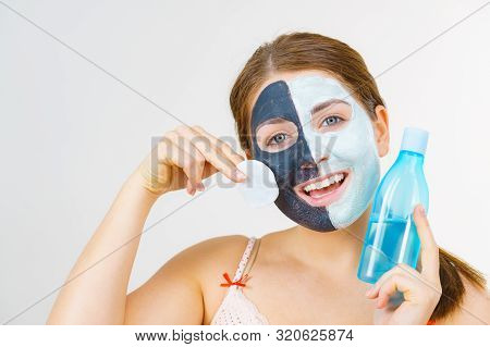 Woman With Clay Carbo Black Mask On One Half Face And White Mud On Second Half. Girl Removing Cosmet