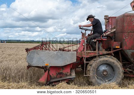 Haselbury Plucknett.somerset.united Kingdom.august 18th 2019.a Vintage Combine Harvester Is Harvesti