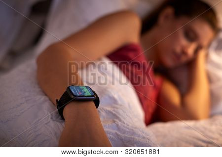 Woman Sleeping In Bed With Focus On Smart Watch She Is Wearing