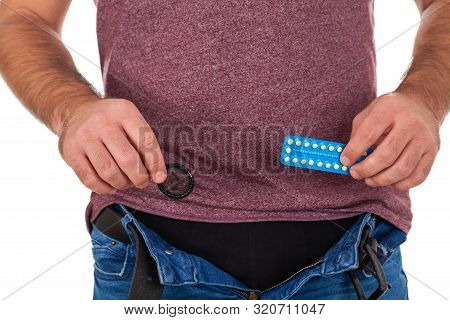 Close Up Picture Of Man Holding Birth Control Pills And Condom - Contraceptive Methods Concept