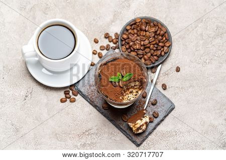 Portion Of Classic Tiramisu Dessert In A Glass Cup On Stone Serving Board And Fres Espresso Coffee O