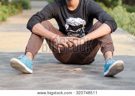 Close Up Cropped Image Of Young Sportsman, Athlete Man In Sports Clothing Sitting On Track And Field