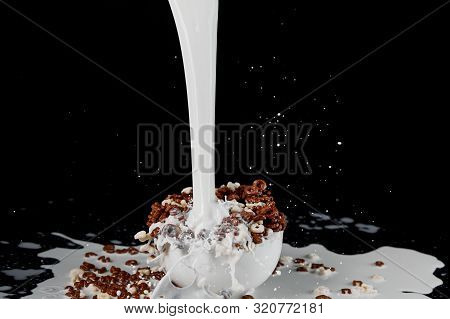 White Bowl With Assorted Cereal With Powerful Milk Stream Isolated On Black