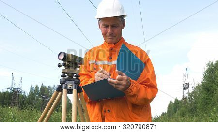 Aged Geodesist Looks Through Dumpy Level Binocular And Notes