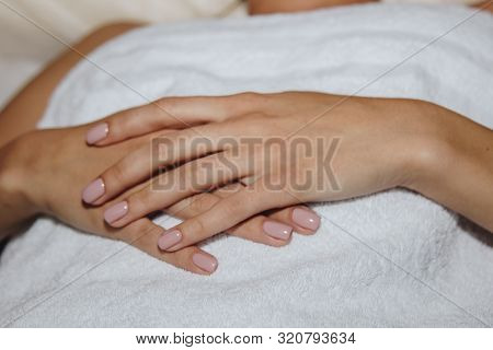 Close-up Female Hands Lie On A White Terry Towel. Preparation For Spa Treatments