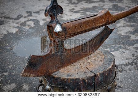 Old Vintage Axe On A Wooden Block Ready To Cut Head.
