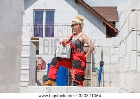 Strong Pretty Woman Working On Construction Site, Building House, Installing Gray Airbricks. Industr