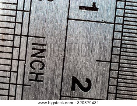 Macro Close-up Of A Stainless Steel Ruler With British And Metric System Measuring Scales: Inches An
