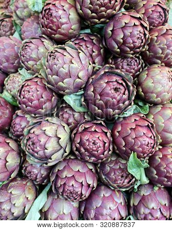 Background Of Green Ripe Artichokes For Sale At The Market