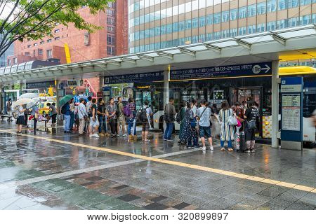 Fukuoka, Japan - 13 July 2019 - Japanese People Wait For Their Bus At A Bus Stop Near Hakata Station