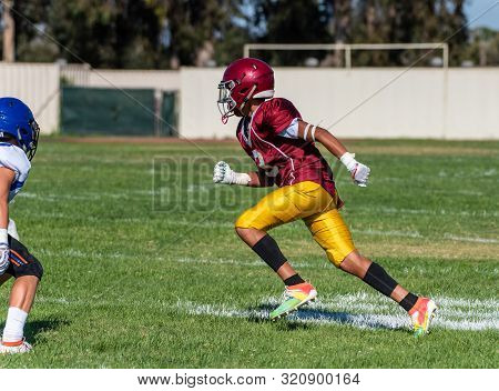 Offensive Football Wide Receiver Runnning His Route During A Play In A Game With Defensive Player Lo