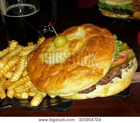 A One Pound Lunker Burger With Fries And A Beer.