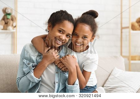 Happy Sisterhood. Cute African American Girls Embracing At Home, Copy Space