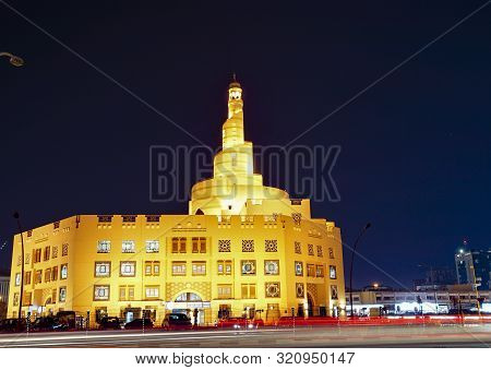 Al Fanar Mosque,  Glowing Golden With Its Spiral Tower Or Minaret Against Dark Night Sky. Doha, Qata