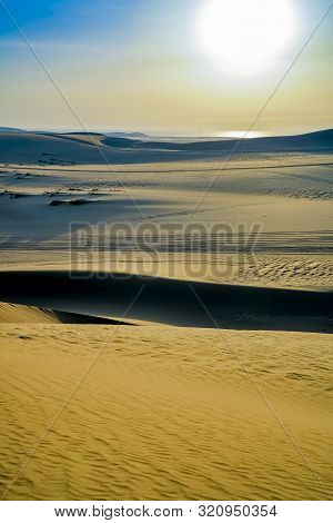 Desert At Sunrise, Sealine Desert Formations With Low Sun Highlighting Leading Face Of Dunes And Rip
