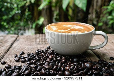 Latte Art Coffee Cup With Coffee Bean On Wood Table