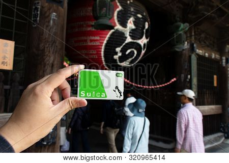 Tokyo, Japan - May 3, 2019 : Man Hold Suica Pass With The Red Lantern Of Narita-san Temple Backgroun