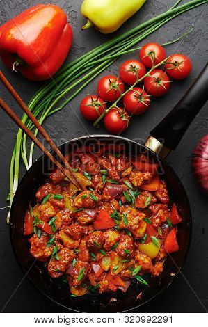 Chicken Manchurian In Pan At Black Concrete Background. Chicken Manchurian Is Indian Chinese Cuisine