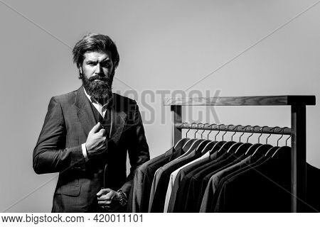 Male Suits Hanging In A Row. Men Clothing, Boutiques. Tailor, Tailoring. Stylish Mens Suit. Man Suit