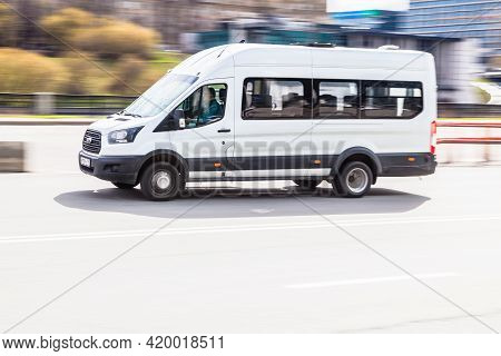 White Ford Van Vehicle On City Road. Fast Moving Car On Moscow Street. Passenger Van Is Fast Transpo