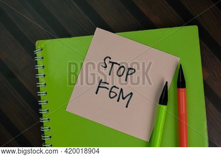 Stop Fgm Write On Sticky Notes Isolated On Wooden Table.