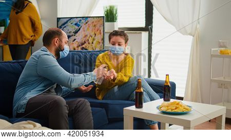 Multi Ethnic Friends Using Hand Gel To Prevent Coronavirus Infection