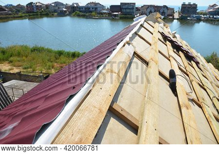 Metal Roofing Construction: A Close-up On An Unfinished Roof Ridge With A Vapor, Moisture Barrier An