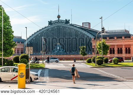 Madrid, Spain - May 1, 2021: Exterior View Of Old Atocha Railway Station. Woman Crossing Street In F