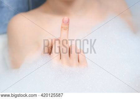 Fuck You Sign By Woman Hand In Foam In Bath, Middle Finger Sign, Closeup View. A Sign Of Aggression,